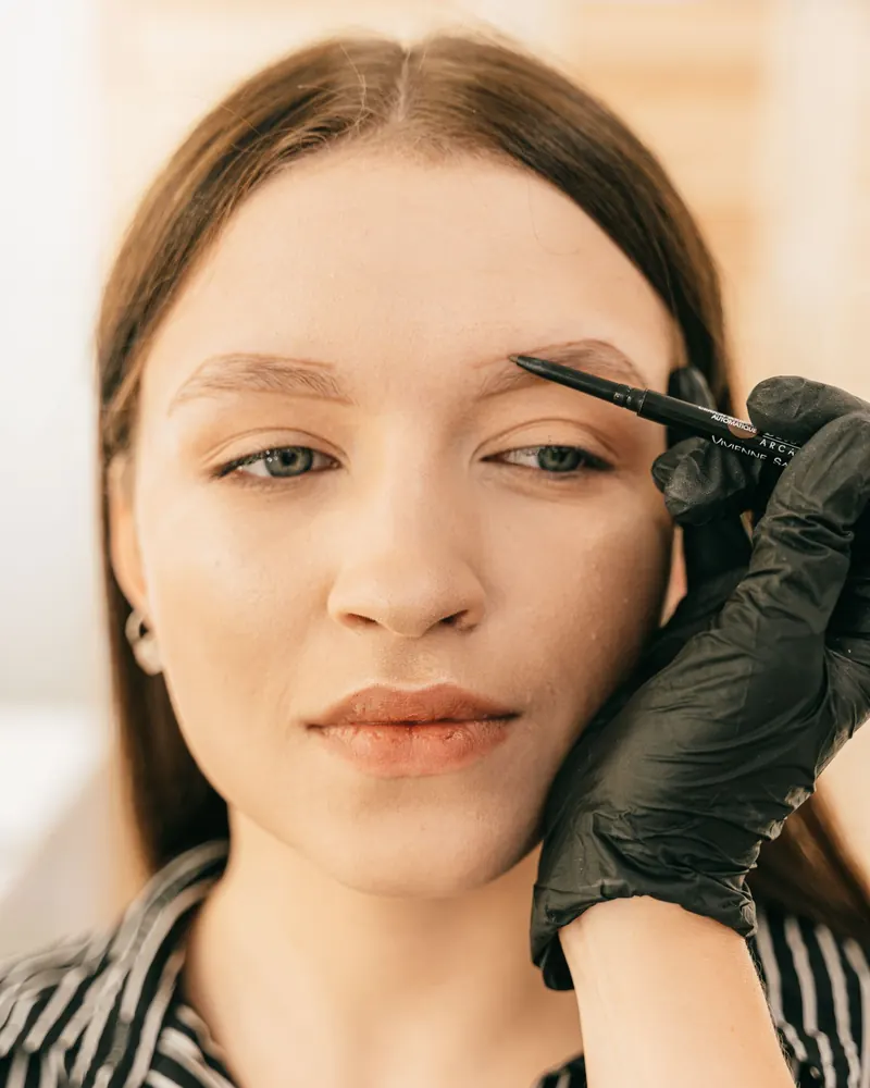 Brow artist shaping a client’s brows