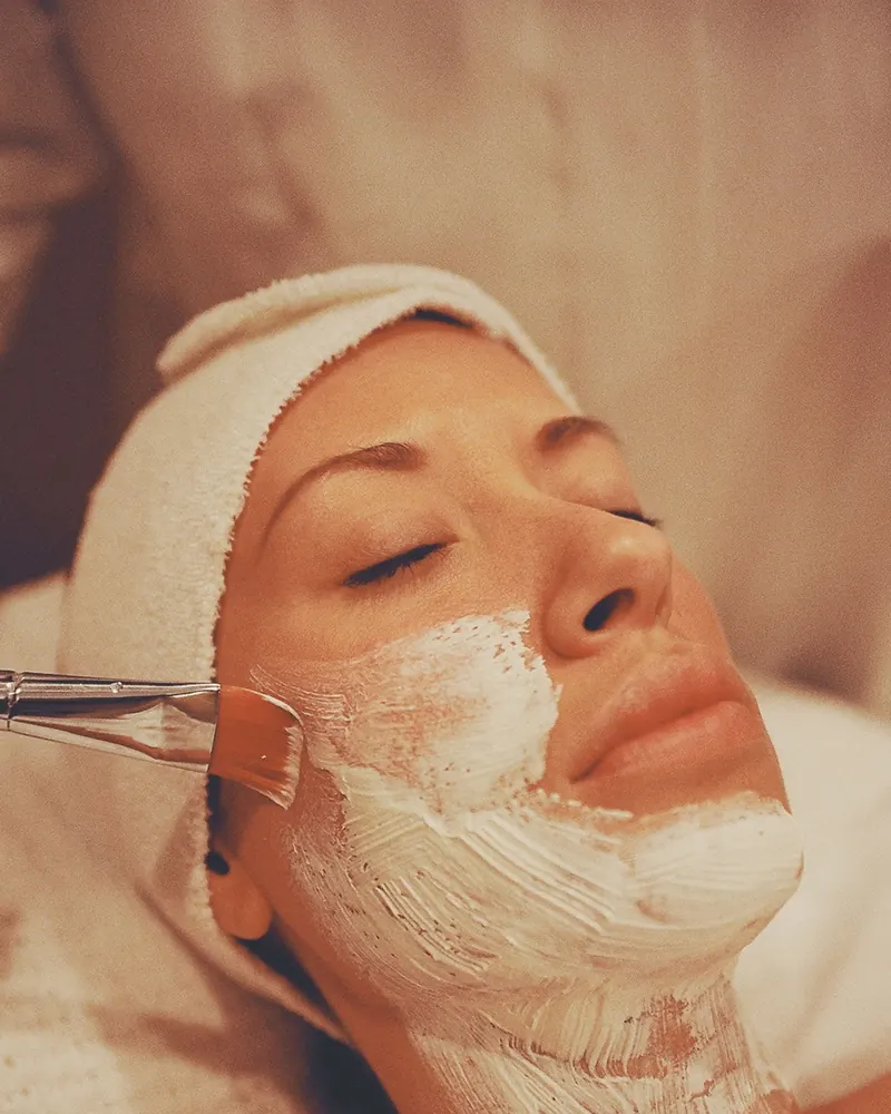 Client relaxing with a cream mask during a facial