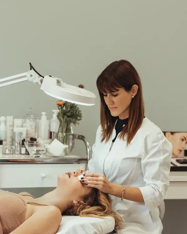 Elena Petrova in a white tunic in the treatment room