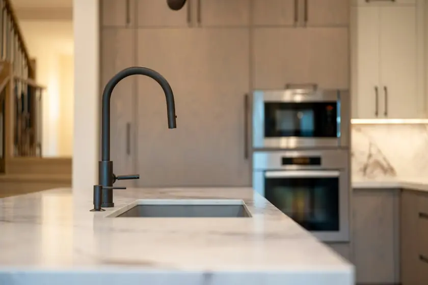 Kitchen island with an undermount sink and black faucet