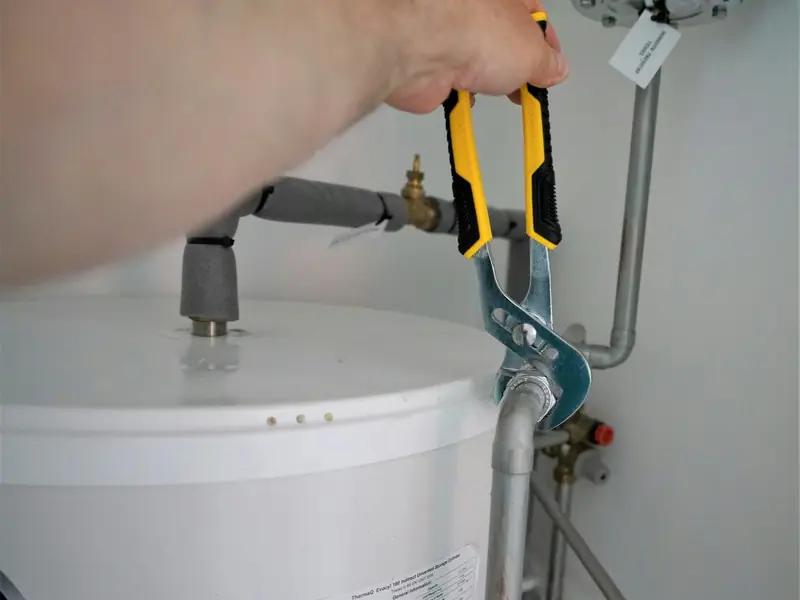 Wrench tightening a fitting on a tank water heater