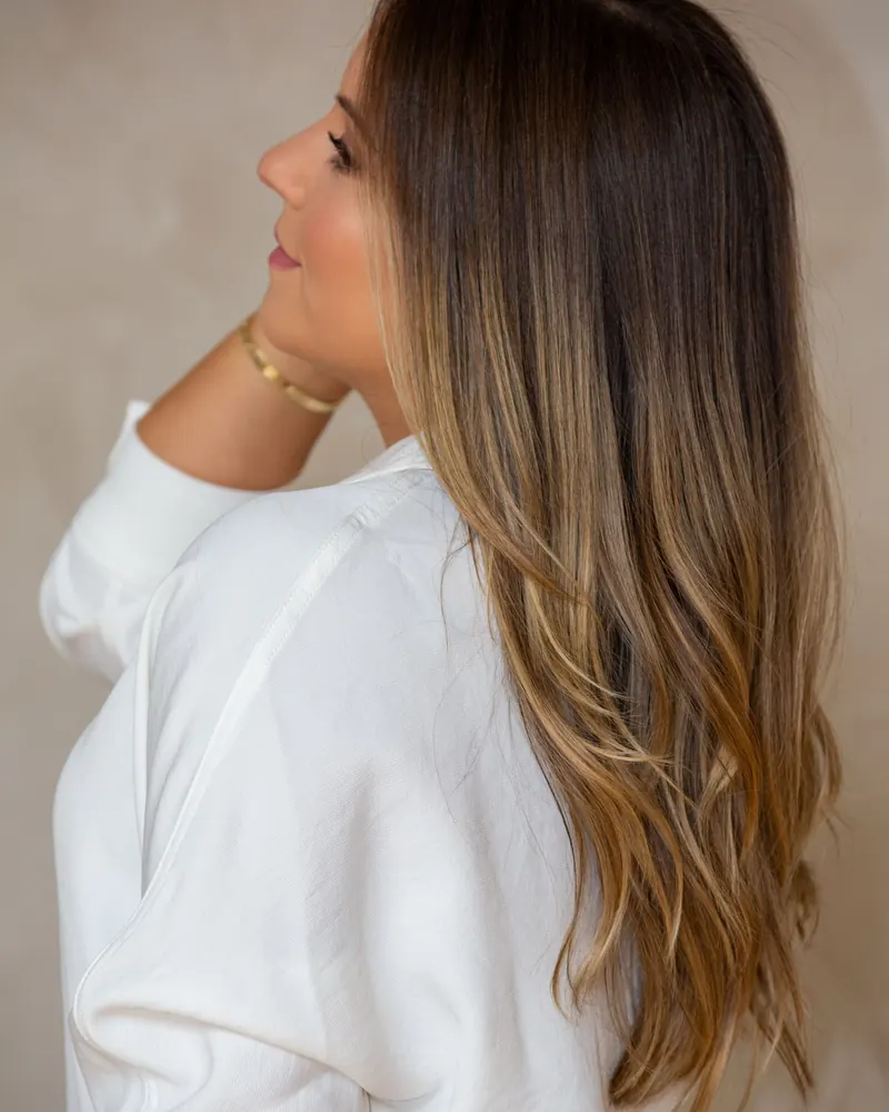 Long brunette hair with soft caramel balayage, seen from the side