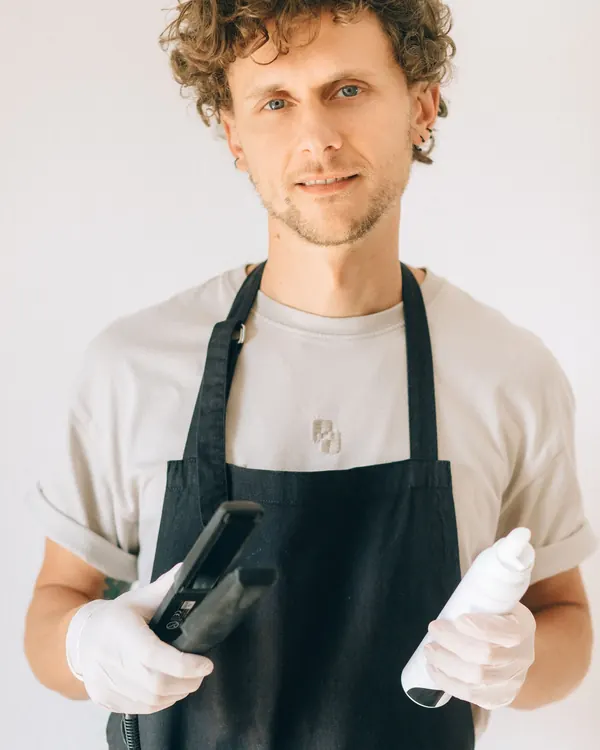 Theo Brandt in a black apron holding styling tools