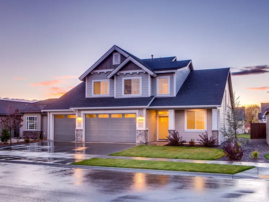 Two-story home with a new gray shingle roof at dusk