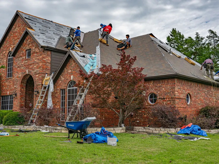 Crew replacing the roof on a brick home