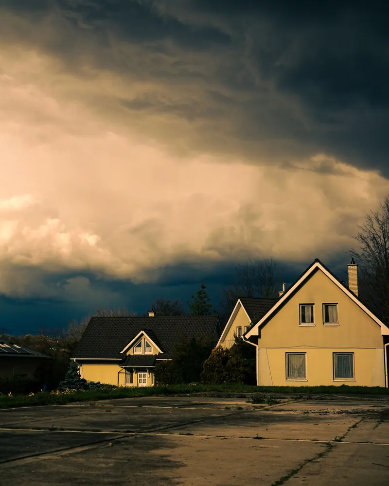 Dark storm clouds building over a yellow house